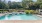 a swimming pool with trees in the background