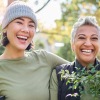 a couple of women holding plants